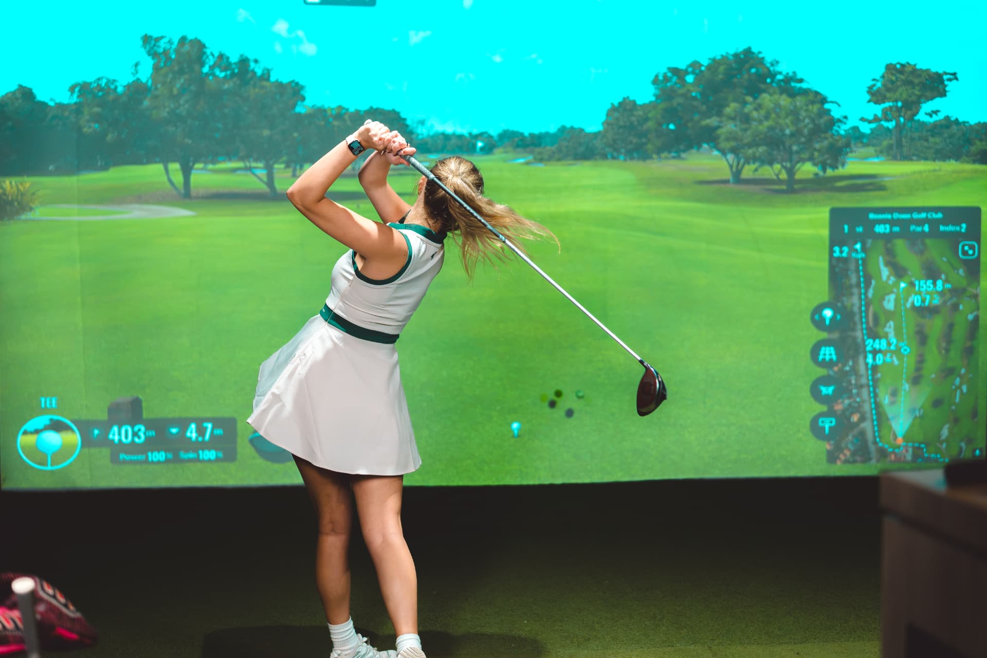 A woman mid-swing at GolfSpace.